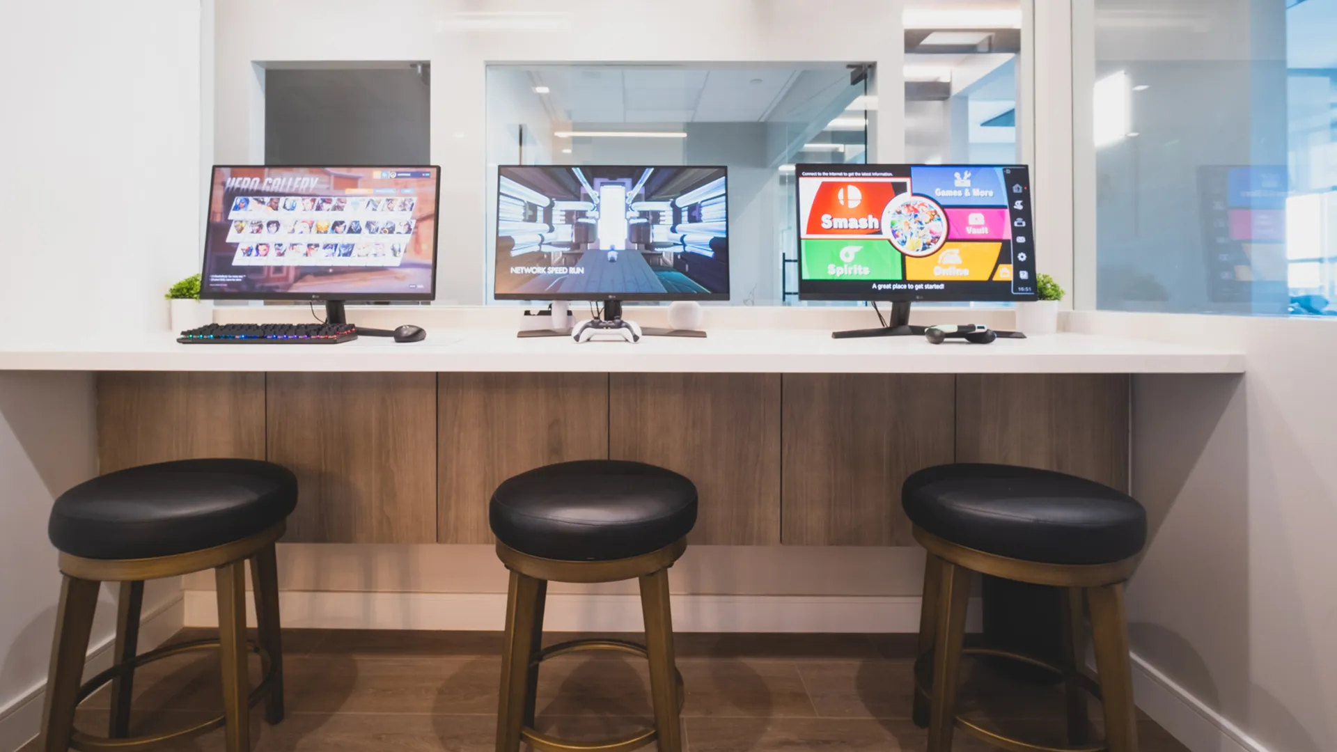 Interactive media station at Aviara Centers with gaming monitors, counter seating, and glass partitions