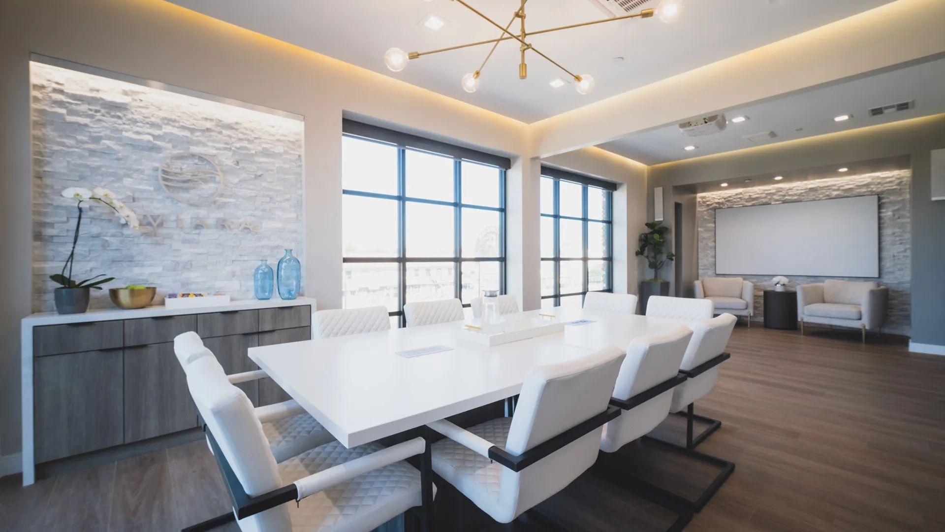 Conference room at Aviara Centers with long white meeting table, upholstered chairs, Aviara feature wall, and presentation screen