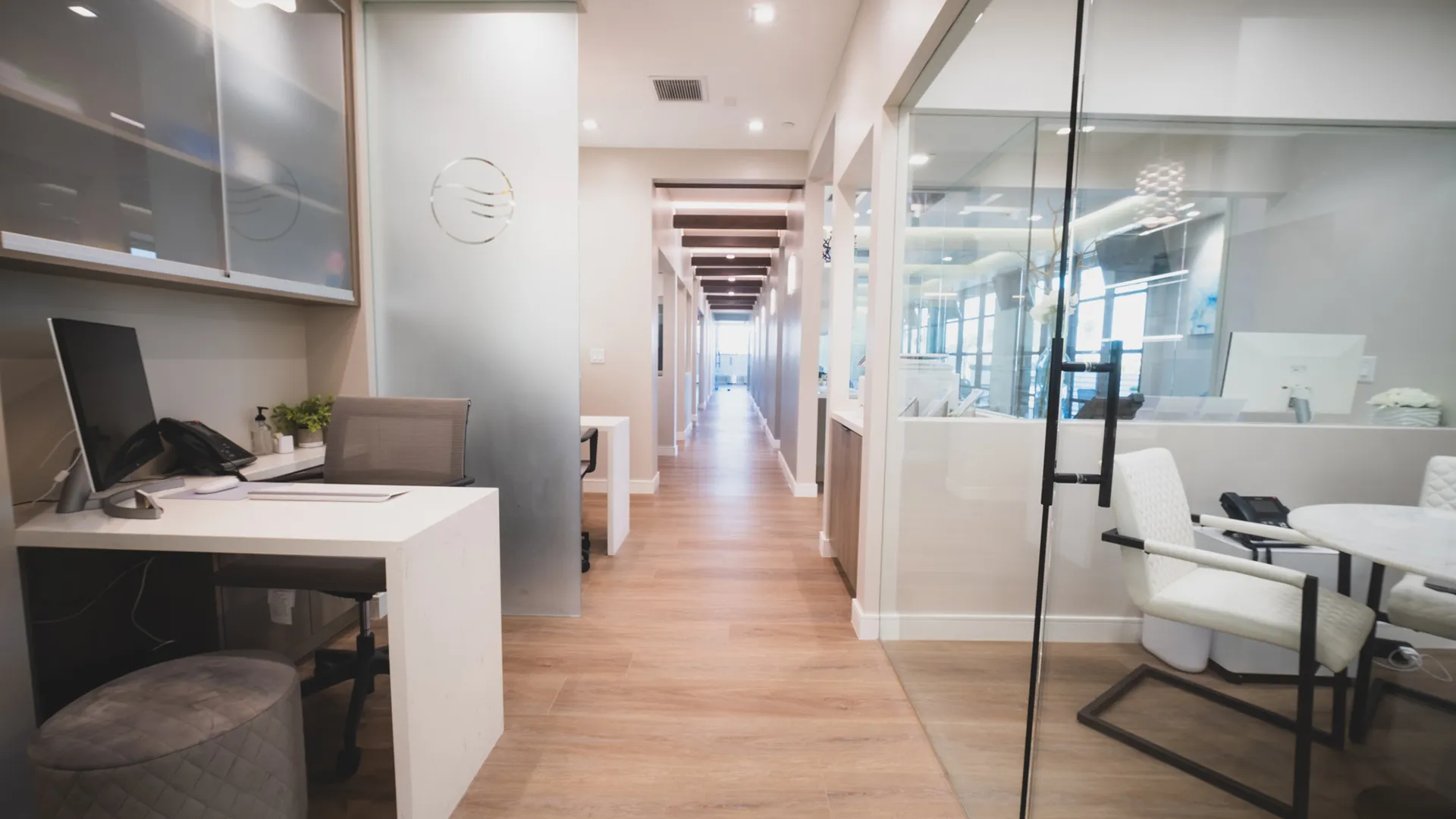 Consultation area at Aviara Centers with private desk workspace, glass meeting room, and hallway leading to treatment rooms